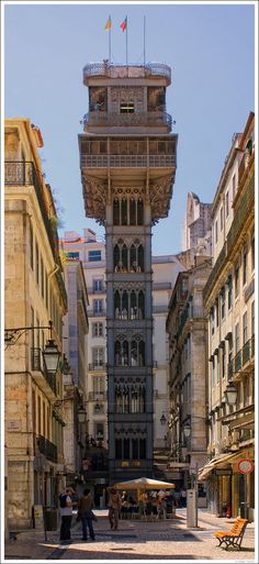 an old building with a tower on top in the middle of a street lined with buildings