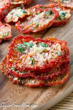 sliced tomatoes with parmesan cheese and herbs on a wooden cutting board, ready to be eaten