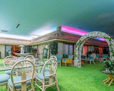 the inside of a house that is decorated with lawn furniture and chairs, as well as an archway