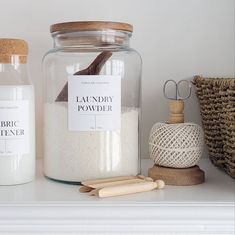 two jars with labels on them sitting on a shelf next to other items and baskets