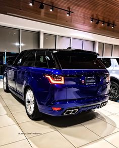 a blue range rover is parked in a showroom