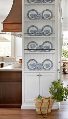 a white bookcase with blue plates on it