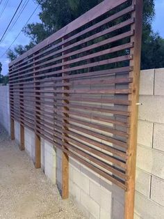 a wooden slatted fence on the side of a building next to a wall