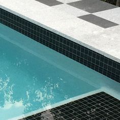 an empty swimming pool with black and white tiles