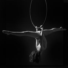 a woman is doing aerial acrobatics with a hoop