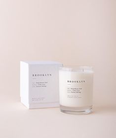 a white candle sitting next to a box on a pink surface with the words save fire printed on it