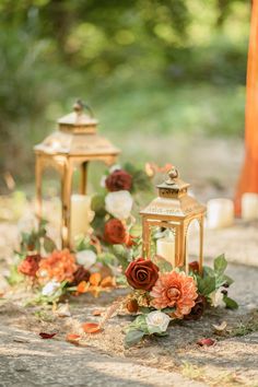 two gold lanterns with flowers on the ground