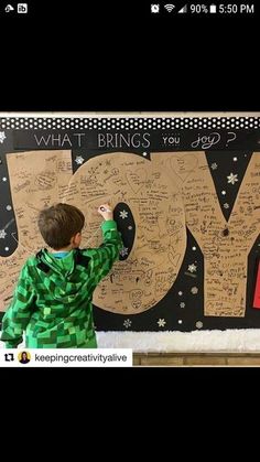 a young boy writing on a bulletin board with the words do what brings you joy