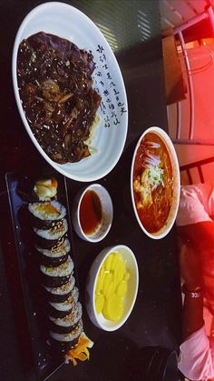 a table topped with plates and bowls filled with different types of food next to each other