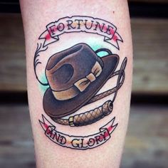 a tattoo on the leg of a man with a hat and rope around it that says fortune and glory