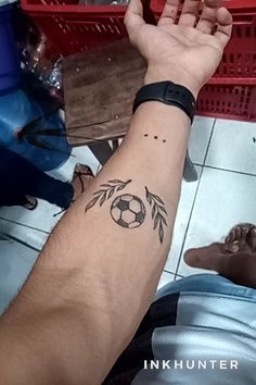 a man with a tattoo on his arm holding a soccer ball in front of him