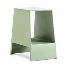 a small green chair sitting on top of a white floor