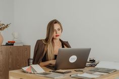 a woman sitting at a desk with a laptop