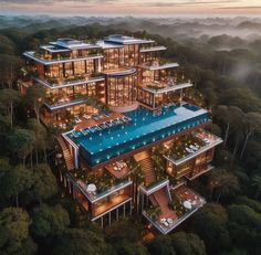 an aerial view of a large building in the middle of some trees with lights on it