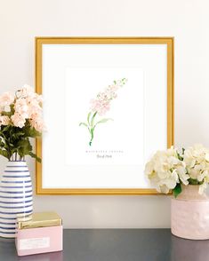 flowers in vases sit on a table next to a framed print with the words, you're beautiful