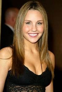 a beautiful young woman with long blonde hair and blue eyes smiling at the camera while wearing a black dress