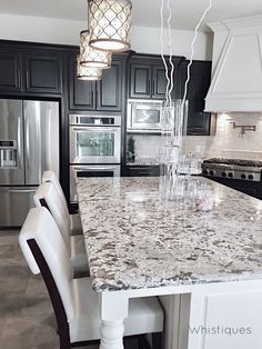 a kitchen with marble counter tops and stainless steel appliances