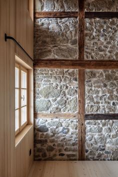 an empty room with stone walls and wooden floors