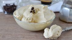 a bowl filled with ice cream next to a spoon on top of a wooden table