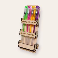 a wooden rack with pens and markers on it