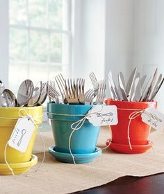 colorful dishes and utensils are arranged in buckets with tags on the lids