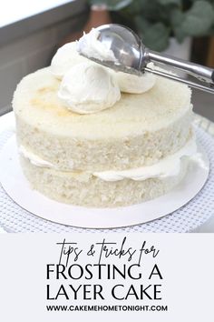 a close up of a cake on a plate with a spoon in it and the words tips & tricks for frosting a layer cake