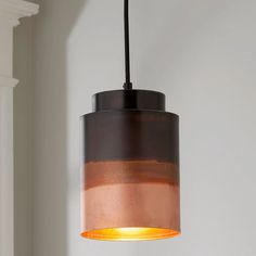 a light hanging from a ceiling in a room with a white wall and window behind it