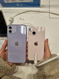 two iphones are being held in front of each other