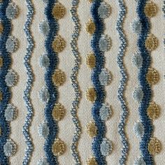 a crocheted blanket with blue and gold circles on it's edges, in the shape of wavy lines