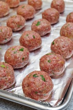 raw meatballs on a baking sheet ready to be cooked in the oven for consumption