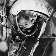 an old black and white photo of a man in a space suit wearing a helmet