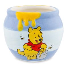 a blue and white ceramic pot with winnie the pooh on it, dripping honey