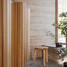 a wooden table sitting next to a plant in a room