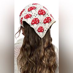 a woman with long hair wearing a red and white knitted mushroom hat on top of her head