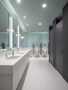 a public restroom with urinals and sinks