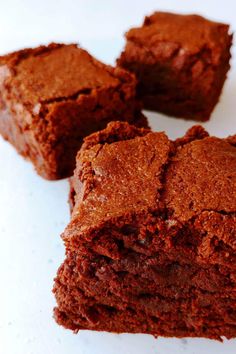 three pieces of brownie sitting on top of a white plate next to each other