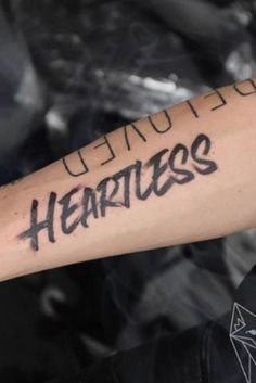 a person with a tattoo on their arm that says, i'm loved my heartless