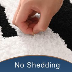 a person is touching the end of a black and white rug