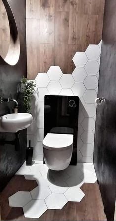 a white toilet sitting inside of a bathroom next to a sink and mirror on the wall