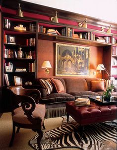 a living room filled with lots of furniture and bookshelves