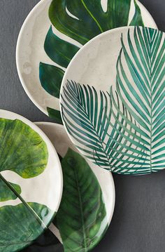 tropical melanine plates with green leaves on the top and bottom, set against a grey background