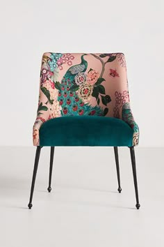 an upholstered chair with peacocks and flowers on it