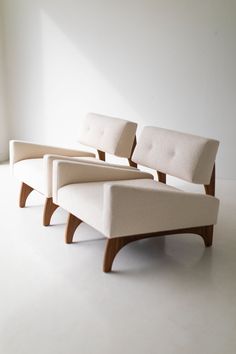 two white chairs sitting next to each other on top of a white carpeted floor