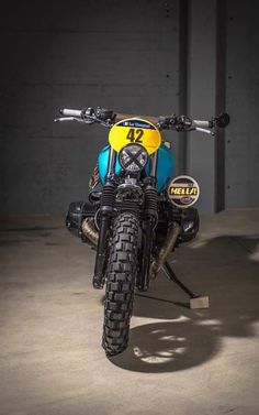 a yellow and blue motorcycle is parked in a parking garage with no one around it