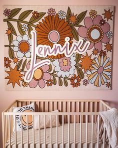 a baby crib in front of a large flower painting