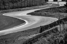 a black and white photo of a winding road