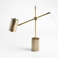 a table lamp that is on top of a white surface and has a metal pole attached to it