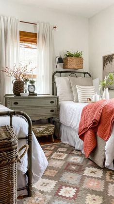 a bed room with a neatly made bed and a basket on the side of the bed