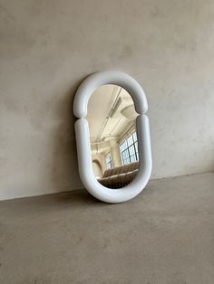 a mirror sitting on top of a cement floor