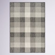 a gray and white checkered rug hanging on a wall